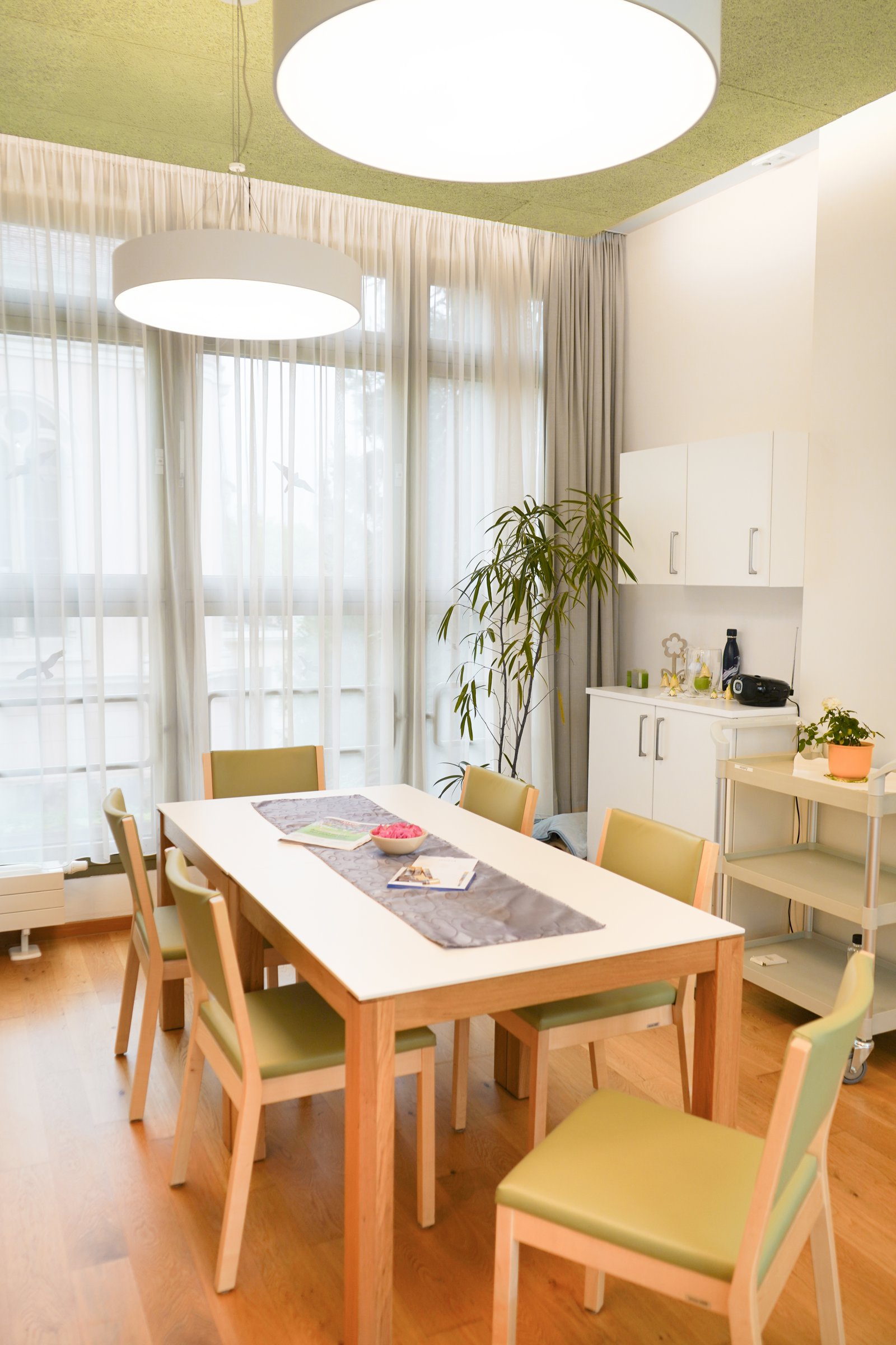 Heller Gemeinschaftsraum mit großem Tisch und Sitzgelegenheiten