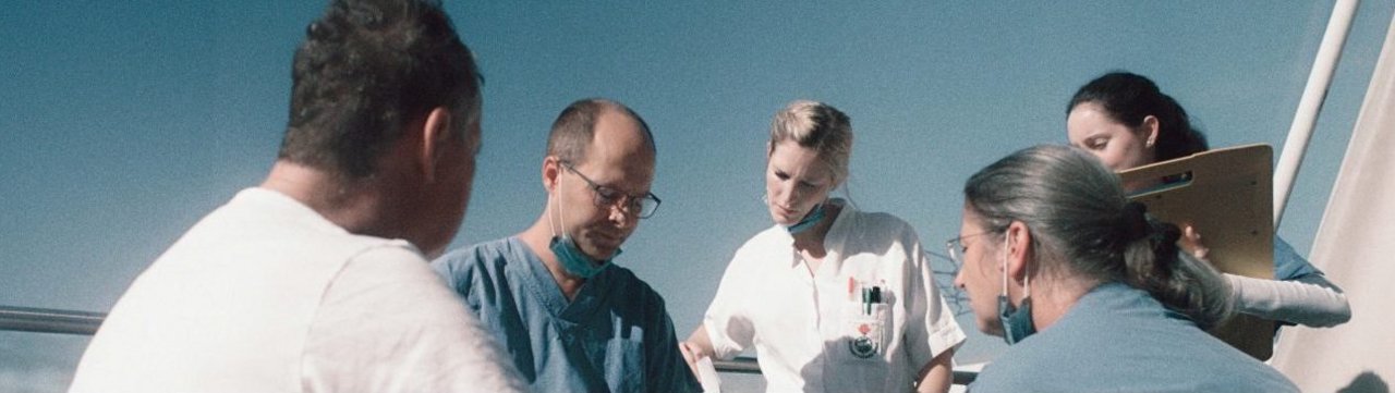 Ärzte und Pflegende stehen im Freien zusammen.